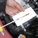 Close up shot of a technician inspecting an Audi's oil dipstick in Georgia.